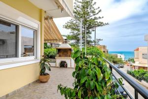 un balcón de una casa con chimenea en Evis coastal comfort house, en Kalamaki