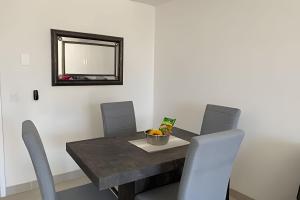 a dining room table with chairs and a mirror at Costa Paraíso D-9 Estudio in Bucerías
