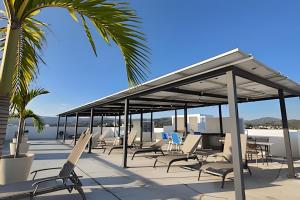 a pavilion on the beach with chairs and a palm tree at Costa Paraíso D-9 Estudio in Bucerías +2 photos