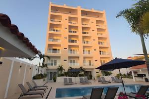 a hotel with a pool and chairs and an umbrella at Costa Paraíso D-9 Estudio in Bucerías