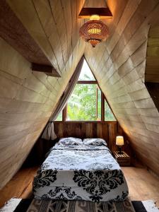 a bed in a room with a large window at Beautiful Cabin in Casa Papagayo, San Marcos, Atitlán in San Marcos La Laguna