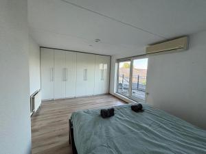 ザルトボメルにあるVakantievilla De Ketelのベッドと大きな窓のある寝室