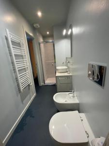 a white bathroom with a toilet and a sink at Casa vacanze Montaldo in Bordighera +19 photos