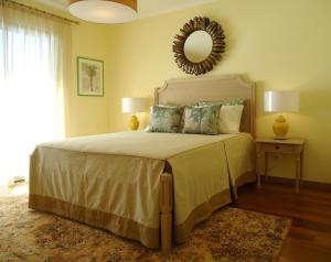 1 dormitorio con 1 cama grande y espejo en la pared en The best sea view in Madeira - Casa Farol en Fajã da Ovelha