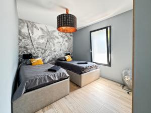 a bedroom with two beds and a large window at Modern 2 bedroom house, sleeps up to 6 in Saint-Didier-de-Formans