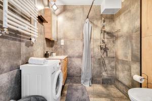 a bathroom with a washing machine and a shower at Sweet Apartment Hydral in Wrocław +5 photos