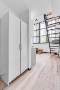 an open living room with white cabinets and a staircase at Sweet Apartment Hydral in Wrocław