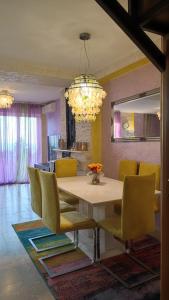 a dining room with a table and yellow chairs at Rezevici AZUR in Budva