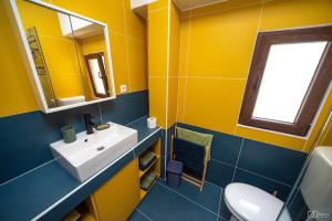 La salle de bains jaune est pourvue d'un lavabo et de toilettes. dans l'établissement 369 Apartment, à Kotor 15 autres photos