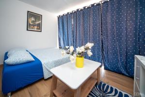 - une chambre avec un lit bleu et une table fleurie dans l'établissement 369 Apartment, à Kotor