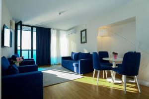 a living room with blue furniture and a table at ORBI CITY OFFiCIALY in Angisa