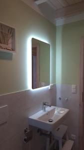 a bathroom with a sink and a mirror at Haus WattErlebnis - Urlaub mit Hund an der Nordseeküste in Sehestedt +17 photos