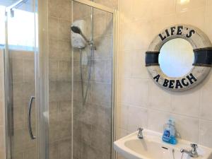 La salle de bains est pourvue d'une douche, d'un miroir et d'un lavabo. dans l'établissement 4 Bed in Ventnor IC169, à Ventnor