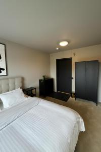 a bedroom with a white bed and two black doors at Lilla Gutebagge Logi in Visby