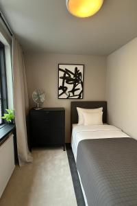 a bedroom with a bed and a lamp and a window at Lilla Gutebagge Logi in Visby