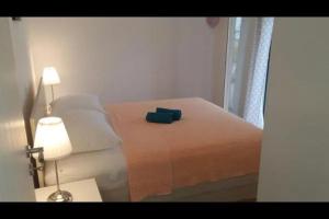 a bedroom with a bed with a lamp and a window at Family Holiday Home in Turanj +7 photos