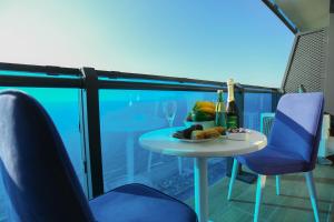 a table with a plate of food and wine on a balcony at ORBI CITY OFFiCIALY in Angisa