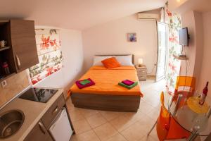 a small bedroom with a bed and a sink at Apartments Vila Masha in Petrovac na Moru