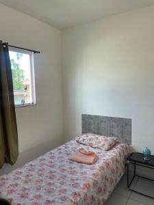 a bedroom with a bed and a window at Apartamento Confortável in Natal