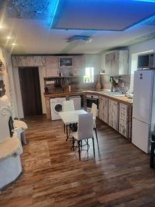 a kitchen with a table and chairs and a white refrigerator at Zöldlak in Kővágótőttős