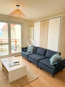 a living room with a blue couch and a table at GC - Le Cocon des 2 Caps - Front de Mer in Wissant +24 photos