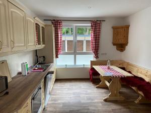 a kitchen with a table and a sink and a window at Ferienwohnungen Mai in Meiningen +14 photos