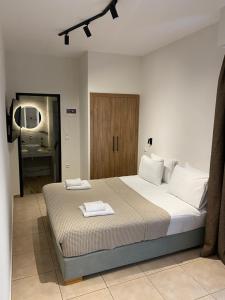 a bedroom with a bed with two towels on it at Villa Nickolas in Paleo Tsifliki