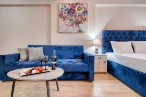 a living room with a blue couch and a table at Valery Apartments in Pefkochori