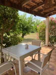 a white table and chairs on a patio at Palauma Plage in Sari Solenzara