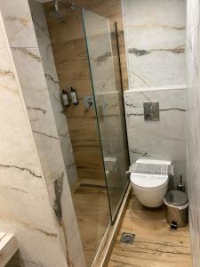 a bathroom with a toilet and a glass shower at Villa Nickolas in Paleo Tsifliki