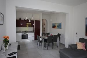 a kitchen and living room with a table and chairs at Il Cortiletto - Cozy Apt Brand New Equipped Private Garden - BBQ in Como