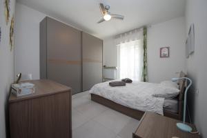 a bedroom with a bed and a table and a ceiling fan at Il Cortiletto - Cozy Apt Brand New Equipped Private Garden - BBQ in Como
