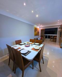 a dining room with a table and chairs at RefugioBacutia- Prédio FRENTE MAR Bacutia- 6 pessoas- 3 Quartos com AR sendo 1 suite - varanda- sala de estar e jantar Ampla -Piscina e Sauna no Prédio in Guarapari