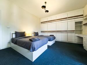 2 camas en un dormitorio con alfombra azul en Modern 3BR Apartment Family Friendly Stay, en El Cairo