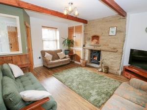 a living room with a couch and a fireplace at Hivewood Cottage in Keighley