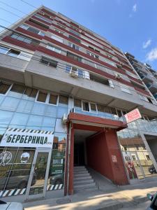 a tallartment building with a red building at SpaNish apartman 6 in Niš
