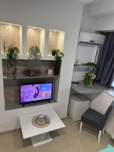 a living room with a tv on a wall at SpaNish apartman 6 in Niš