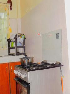 a kitchen with a stove with a pot on it at Stivo apartment in Nakuru +2 photos