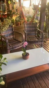 een potplant op een tafel met twee stoelen bij Casa em Condomínio Residencial Aroeira 500 m Da Praia - Geriba - Armação Dos Búzios in Búzios