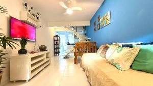 een woonkamer met een bank en een blauwe muur bij Casa em Condomínio Residencial Aroeira 500 m Da Praia - Geriba - Armação Dos Búzios in Búzios