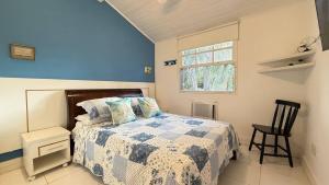 een slaapkamer met een bed met een blauwe muur bij Casa em Condomínio Residencial Aroeira 500 m Da Praia - Geriba - Armação Dos Búzios in Búzios +22 foto's