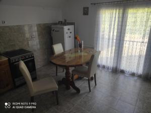 a dining room with a table and chairs and a refrigerator at Kuća za odmor Matić in Bajina Bašta +7 photos