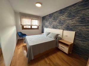 a bedroom with a bed and a wall with a mural at Vista Santa Mariña in Cambados