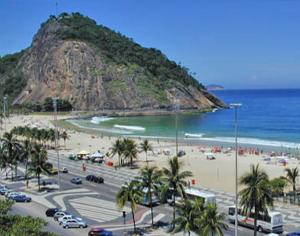 una playa con palmeras y una playa con coches en Apartamento No Leme, en Río de Janeiro