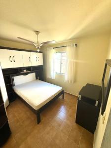 a small bedroom with a bed and a window at Apartamento 206 in Guaratuba