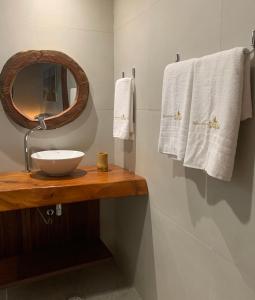 a bathroom with a sink and a mirror and towels at Jangadas do Toque Milagres Flats no Térreo in São Miguel dos Milagres +49 photos