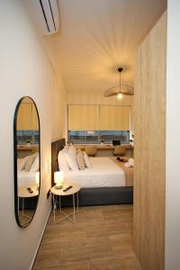 ein Schlafzimmer mit einem großen Bett und einem Spiegel in der Unterkunft Blisséa in Piräus
