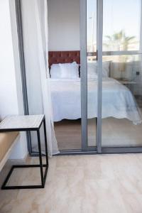 a bedroom with a bed and a table and a window at Luxe résidence Hivernage in Agadir