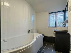 a white bathroom with a tub and a toilet at 1 Bed in Bridport 89687 in Bridport +14 photos