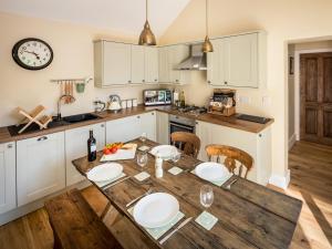 a kitchen with a wooden table with white cabinets at 2 Bed in Baslow SKN18 in Baslow